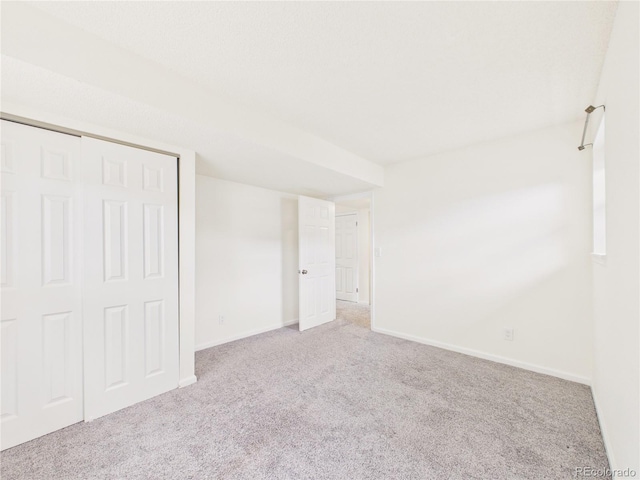 unfurnished bedroom featuring carpet, a closet, and baseboards