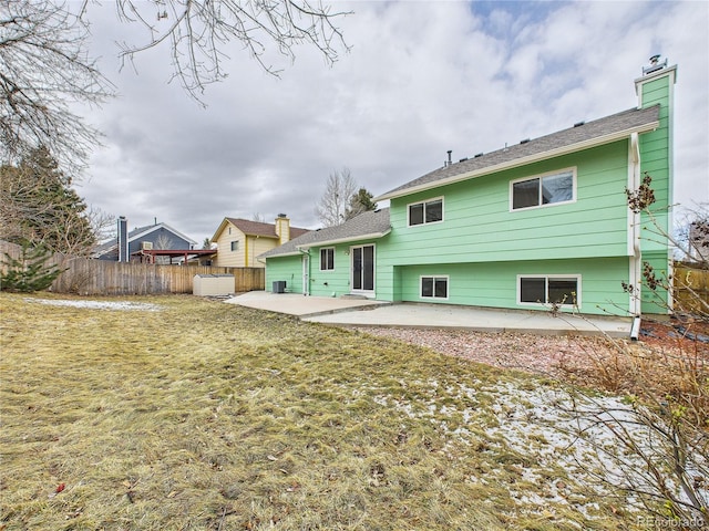 rear view of house featuring a yard, a chimney, a patio, and fence