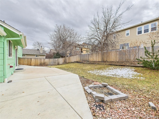 view of yard with a patio area, a fenced backyard, and an outdoor fire pit