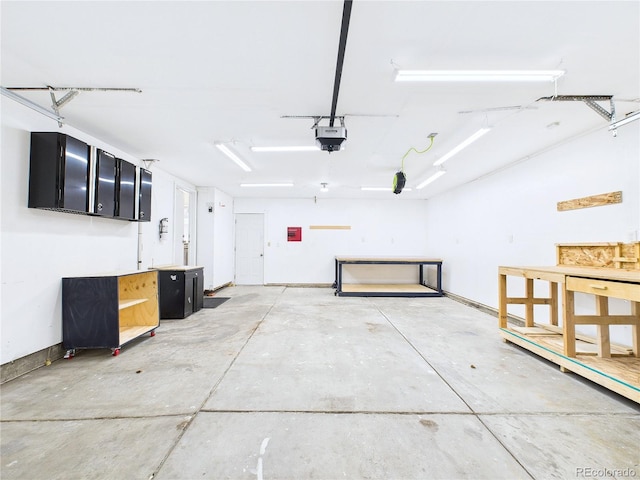 garage featuring a garage door opener and baseboards