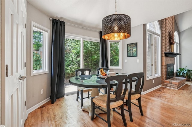 5564 S Jasper Way, Centennial, CO 80015 - dining space featuring light wood-type flooring and a brick fireplace