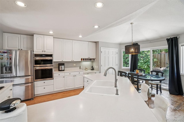5564 S Jasper Way, Centennial, CO 80015 - kitchen featuring appliances with stainless steel finishes, recessed lighting, light countertops, white cabinets, and light wood-style flooring