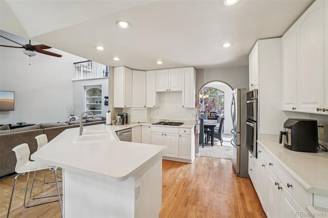 5564 S Jasper Way, Centennial, CO 80015 - kitchen with a peninsula, a ceiling fan, a kitchen bar, light wood-style flooring, and open floor plan