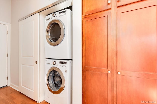 washroom featuring light hardwood / wood-style floors and stacked washing maching and dryer