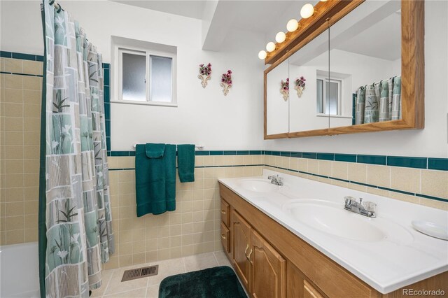 266 Gap Rd, Black Hawk, CO 80422 - bathroom featuring double vanity, tile walls, tile patterned floors, wainscoting, and shower / tub combo