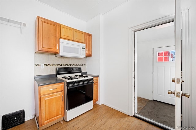 kitchen featuring range with gas cooktop, light hardwood / wood-style floors, and backsplash