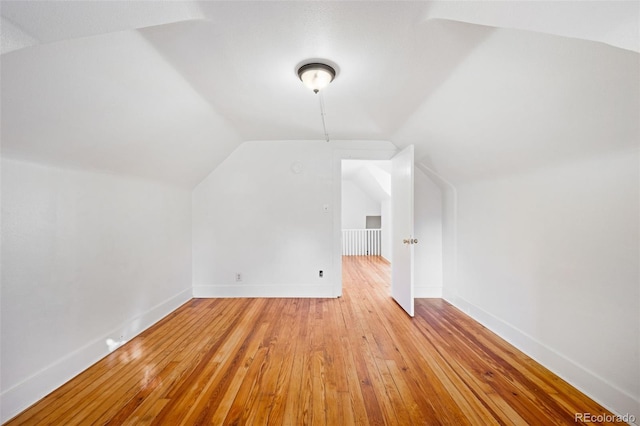 bonus room with light hardwood / wood-style flooring and vaulted ceiling