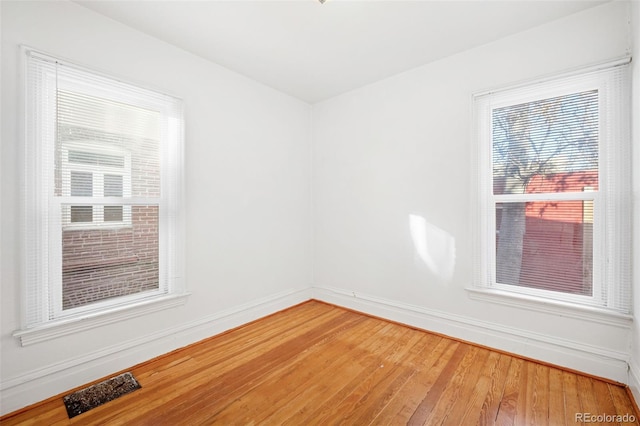 unfurnished room with hardwood / wood-style flooring