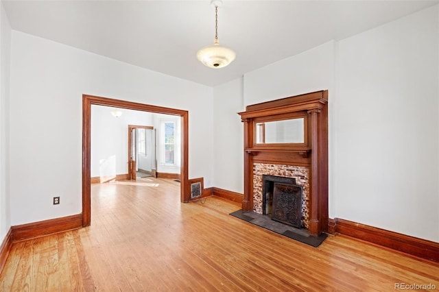 unfurnished living room featuring a fireplace and wood-type flooring