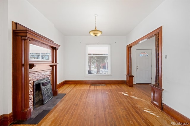 unfurnished living room featuring a fireplace and wood-type flooring