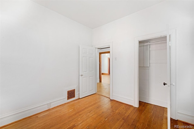 unfurnished bedroom featuring hardwood / wood-style floors and a closet