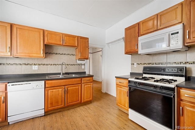 kitchen featuring sink, white appliances, backsplash, and light wood-type flooring