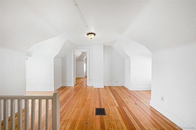 bonus room with vaulted ceiling and light hardwood / wood-style flooring