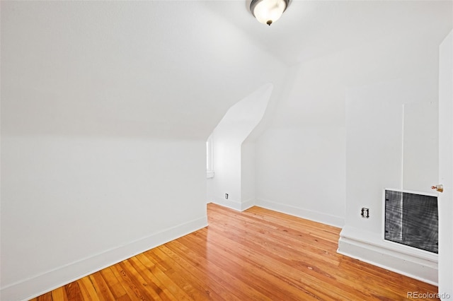 bonus room with vaulted ceiling and light hardwood / wood-style flooring