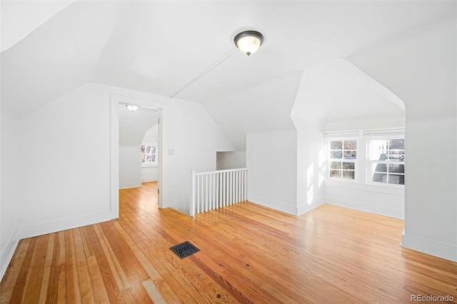 additional living space featuring wood-type flooring and lofted ceiling