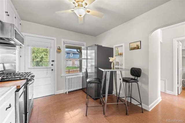 2616 Utica St, Denver, CO 80212 - kitchen featuring radiator, appliances with stainless steel finishes, white cabinets, a ceiling fan, and baseboards