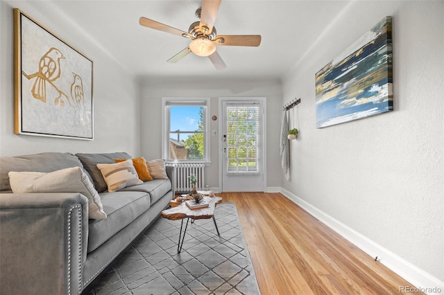 2616 Utica St, Denver, CO 80212 - living room featuring radiator heating unit, wood finished floors, baseboards, and a ceiling fan