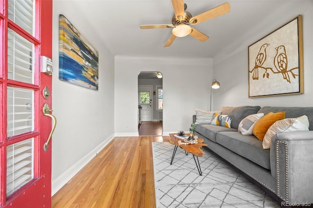 2616 Utica St, Denver, CO 80212 - living room featuring arched walkways, wood finished floors, a ceiling fan, and baseboards
