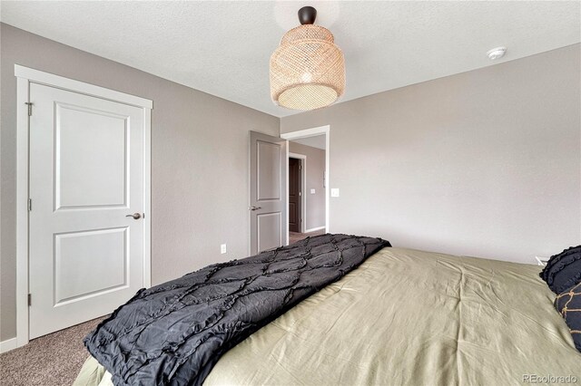 carpeted bedroom featuring a textured ceiling