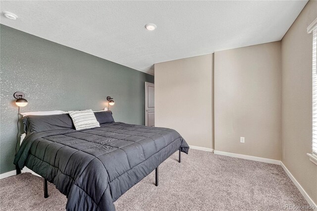 carpeted bedroom featuring baseboards, a textured ceiling, and a textured wall