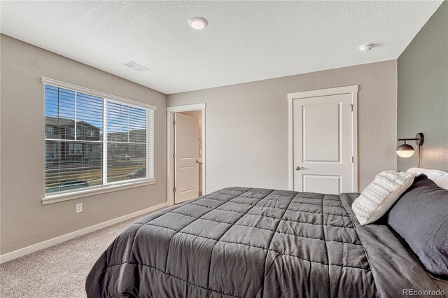 carpeted bedroom featuring a textured ceiling, a textured wall, visible vents, and baseboards