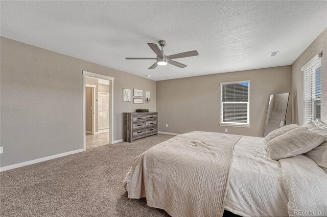 bedroom featuring a textured ceiling, carpet flooring, a ceiling fan, visible vents, and baseboards