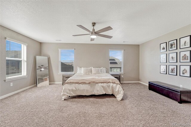 bedroom featuring a ceiling fan, carpet, a textured ceiling, and baseboards