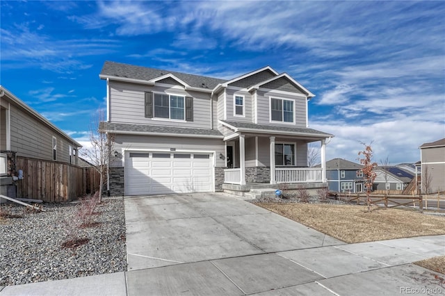 view of front of house featuring a porch, stone siding, driveway, and fence