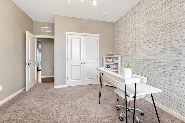 office area featuring carpet, brick wall, visible vents, and baseboards