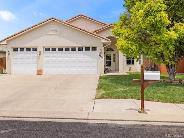 mediterranean / spanish-style home featuring a front yard and a garage