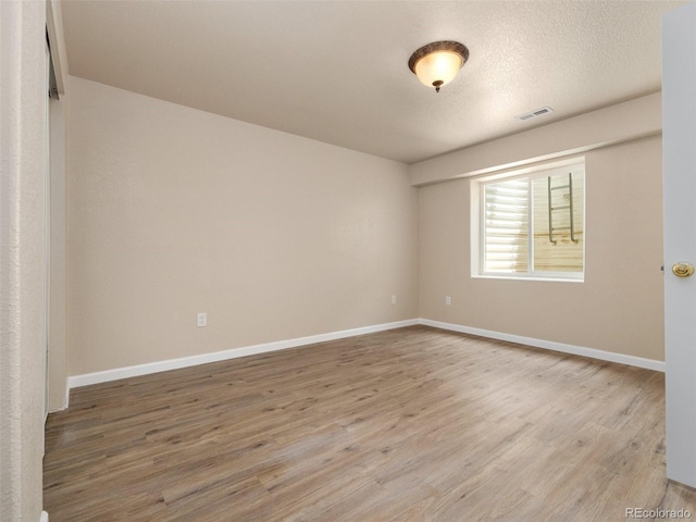 empty room featuring a textured ceiling and hardwood / wood-style flooring