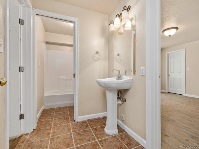 bathroom with hardwood / wood-style flooring, a shower, and sink