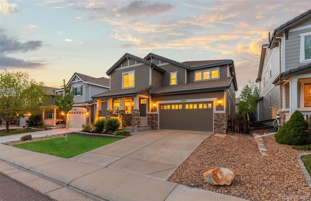 craftsman-style house featuring an attached garage, stone siding, and concrete driveway