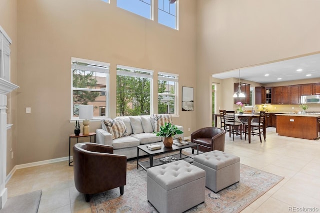 living area with a high ceiling, light tile patterned floors, baseboards, and recessed lighting