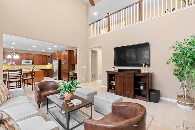 living area with a high ceiling, baseboards, recessed lighting, and light tile patterned floors