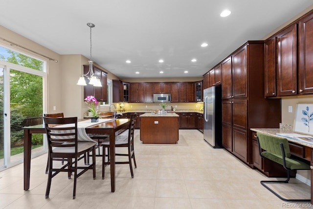 kitchen featuring appliances with stainless steel finishes, recessed lighting, glass insert cabinets, a center island, and pendant lighting