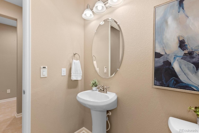 bathroom featuring toilet and baseboards