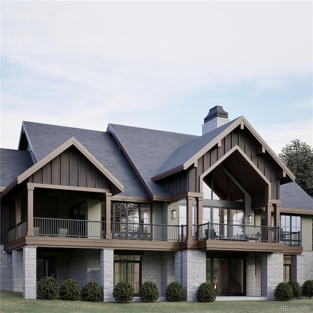 rear view of property with a yard and a balcony