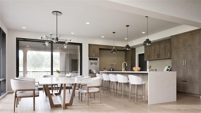 kitchen featuring sink, tasteful backsplash, a notable chandelier, double oven, and dark brown cabinets