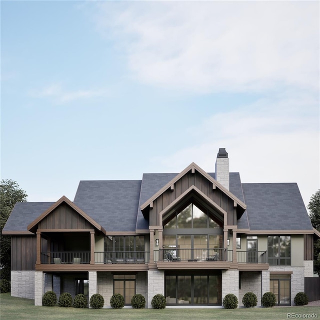 rear view of property with a yard and a balcony