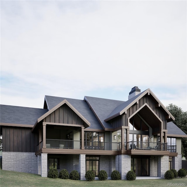 back of house with a lawn and a balcony