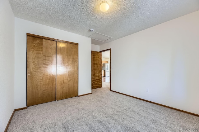 17692 E Brown Cir, Aurora, CO 80013 - unfurnished bedroom with carpet floors, attic access, a closet, a textured ceiling, and white fridge with ice dispenser
