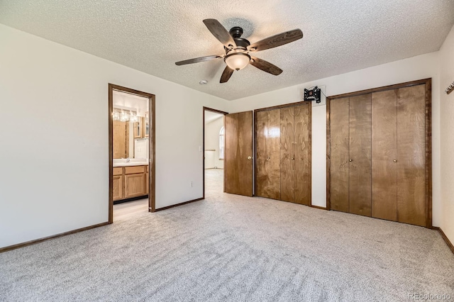 17692 E Brown Cir, Aurora, CO 80013 - unfurnished bedroom featuring light carpet, two closets, a textured ceiling, ensuite bathroom, and ceiling fan