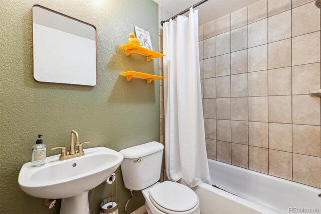7317 Fremont Pl, Larkspur, CO 80118 - full bathroom featuring shower / tub combo, toilet, a textured wall, and a sink