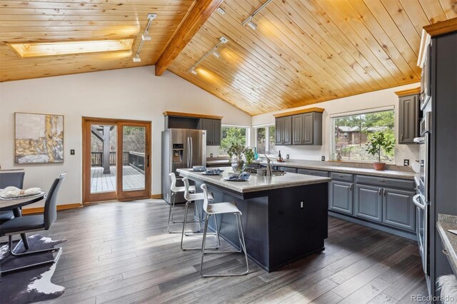 7317 Fremont Pl, Larkspur, CO 80118 - kitchen featuring stainless steel fridge, a kitchen island, a wealth of natural light, and wood ceiling