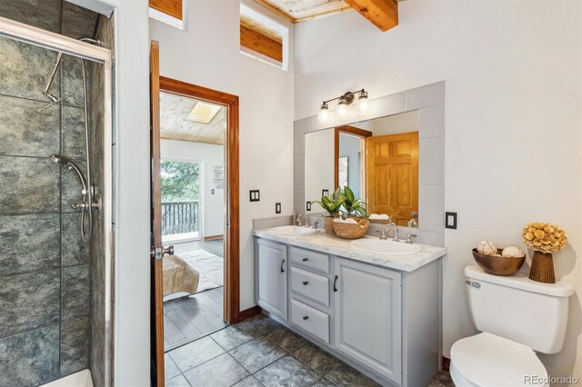 7317 Fremont Pl, Larkspur, CO 80118 - bathroom featuring a sink, double vanity, toilet, beamed ceiling, and a shower stall