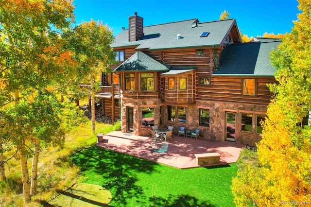 rear view of house featuring a yard, a deck, and a patio area