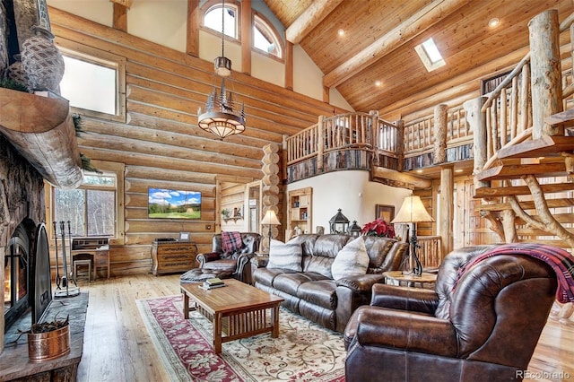 living room featuring beamed ceiling, hardwood / wood-style floors, log walls, a fireplace, and high vaulted ceiling