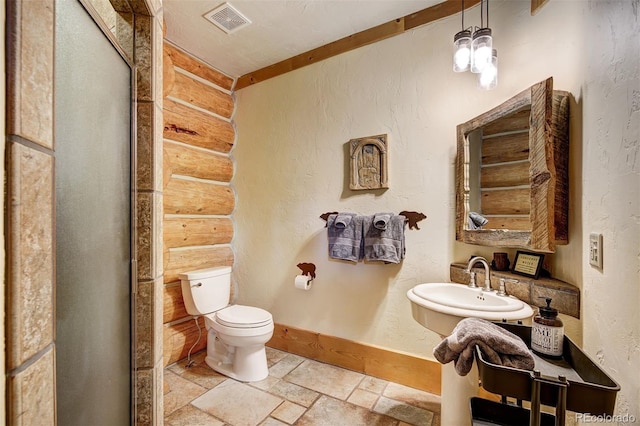 bathroom featuring sink, a chandelier, and toilet