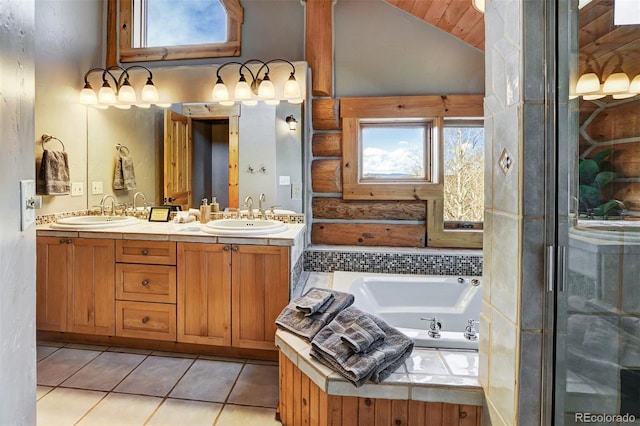 bathroom featuring tile patterned flooring, a bathtub, vaulted ceiling, and vanity